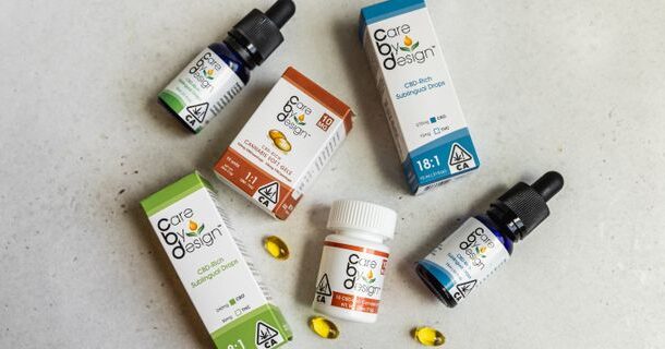 Care by Design CBD products including sublingual drops, capsules, and tinctures arranged on a light surface